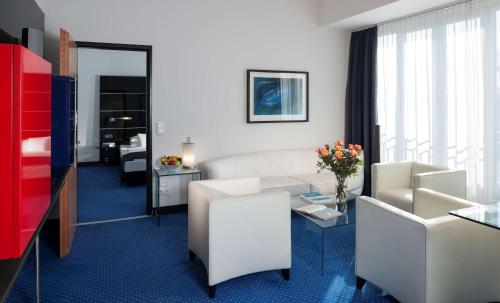 a living room with a couch and a table at Dorint Hotel Potsdam in Potsdam
