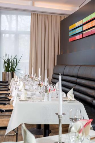 a long white table with white candles on it at Dorint Hotel Potsdam in Potsdam