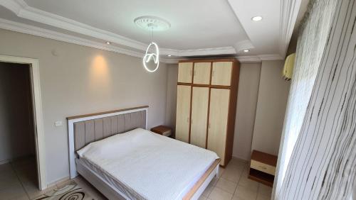 a small bedroom with a bed and a ceiling at Cleopatra plajına 50mt deniz gören ferah 2+1 daire in Alanya