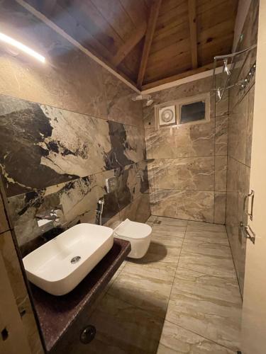 uma casa de banho com um lavatório e um WC em The Tiger Claw Resort em Ramnagar