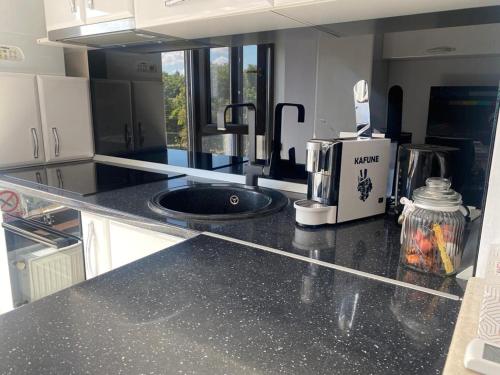 a kitchen with a black counter top with a sink at Copou Residence in Iaşi