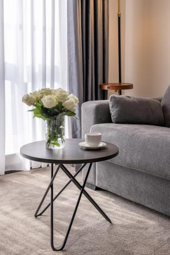 a vase of flowers on a table in a living room at Derand Hotel in Pristina