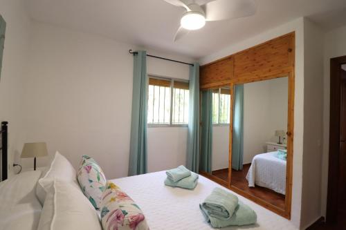 a bedroom with a white bed and a mirror at Villa el Barco Spainsunrentals 1200 in Nerja