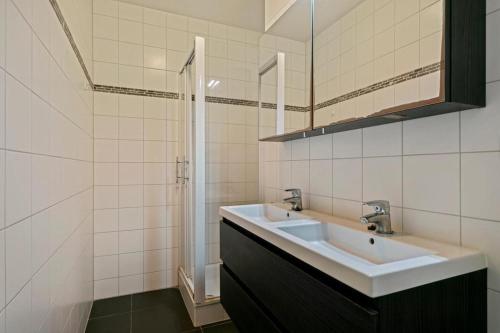 a white bathroom with a sink and a shower at Apartment in Heart of Brussel City with Balcony View in Brussels