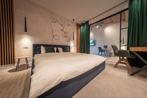 a bedroom with a large bed and a table at The Public Aparthotel 2 in Făgăraş