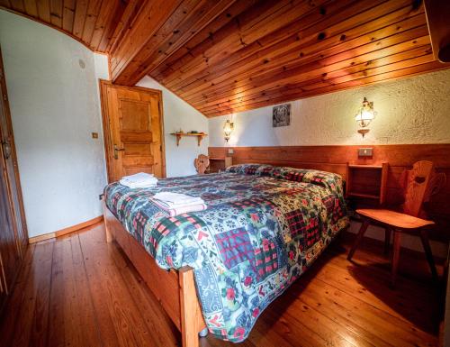 a bedroom with a bed and a wooden ceiling at Chalet della Civetta 