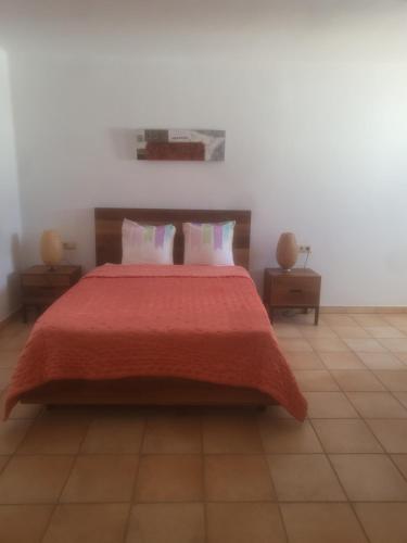 - une chambre avec un grand lit et une couverture rouge dans l'établissement Siesta el por del sol, à Santa Eulària des Riu