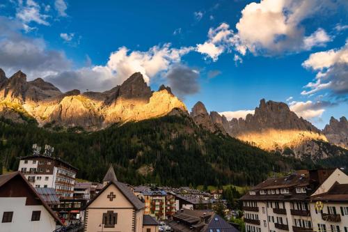 a town in the mountains with houses and buildings at Hotel Cima Rosetta - BW Signature Collection in San Martino di Castrozza