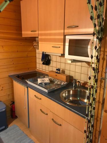 a kitchen with a sink and a microwave at Ferienhaus Nele - a90930 in Kühlungsborn