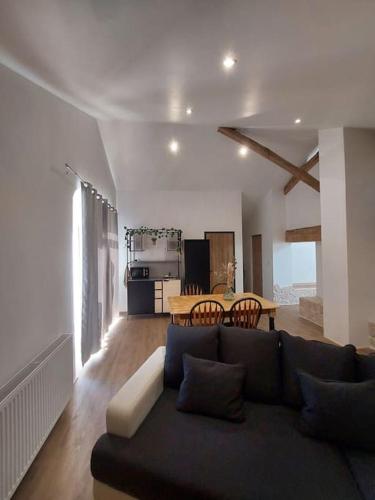 un salon avec un canapé et une table dans l'établissement Maison de la nature, à Bussière-Galant