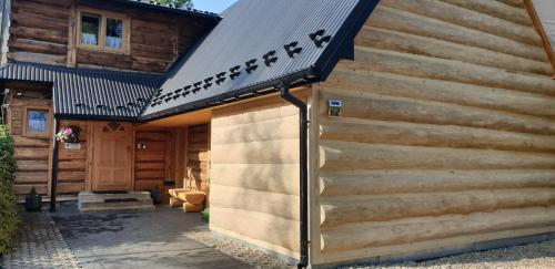 a wooden cabin with a gambrel roof at Domeczek Góralski Zakopane in Zakopane
