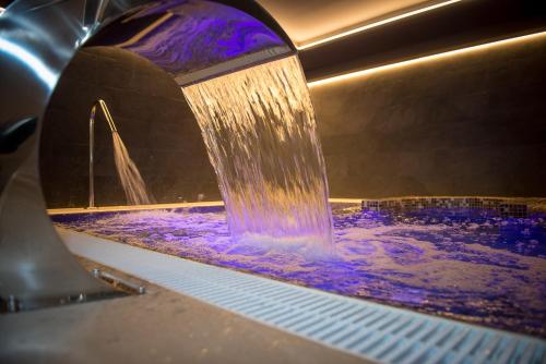 a water fountain in a room with purple lights at Oroel Hotel & SPA in Jaca