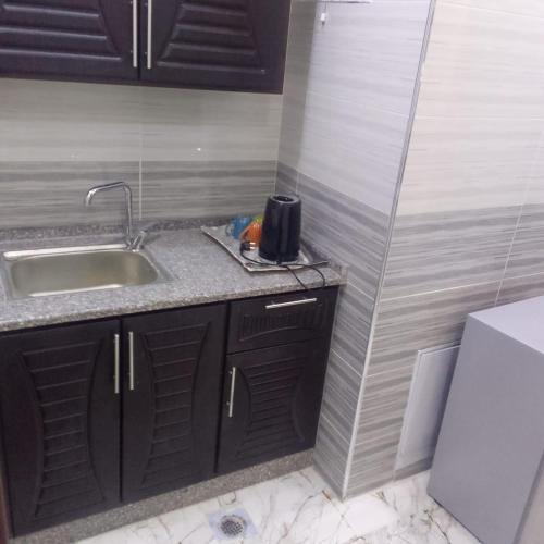 a small kitchen with a sink and a counter top at dream house hotel in Jerash
