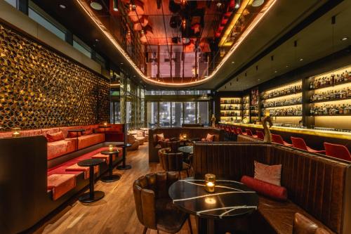 a restaurant with couches and tables and wine bottles at Hotel Kö59 Düsseldorf - Member of Hommage Luxury Hotels Collection in Düsseldorf