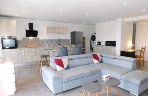 a living room with a blue couch and a kitchen at Stunning T4 Musardière in Antibes