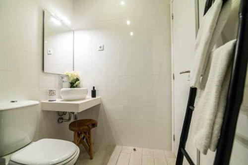 uma casa de banho branca com um lavatório e um WC em RECANTO DO AÇOR Holiday Accommodation em Ponta Delgada