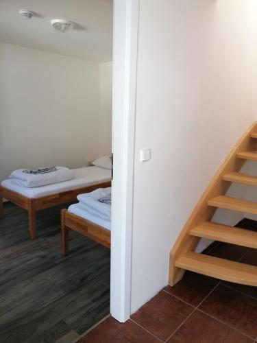 a room with a bed and a staircase and a room with a bed gmaxwell gmaxwell at Chaty a Apartmány Hracholusky Kemp Kosatka in Pňovany