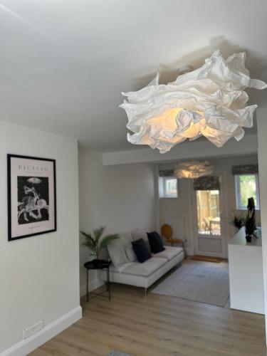 a living room with a large white chandelier at Summertown Oxford- Entire 4 bedroom home, sleeps up to 10- 10 mins to city centre in Oxford