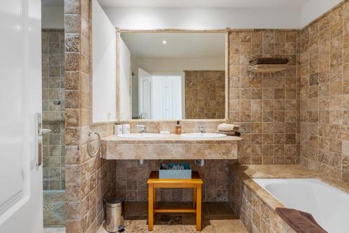 y baño con 2 lavabos, bañera y espejo. en Los Flamingos Luxurious-Royal Flamingos, en Estepona