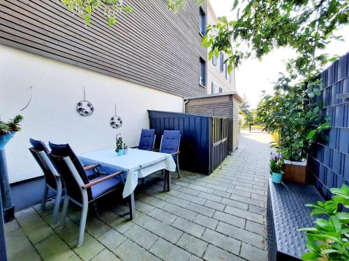 un patio con una mesa blanca y sillas en Ferienwohnung Scharnhorst, en Teningen