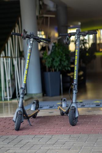 a pair of scooters sitting on a sidewalk at LAT Hotel & Apartmenthaus Berlin in Eisenhüttenstadt