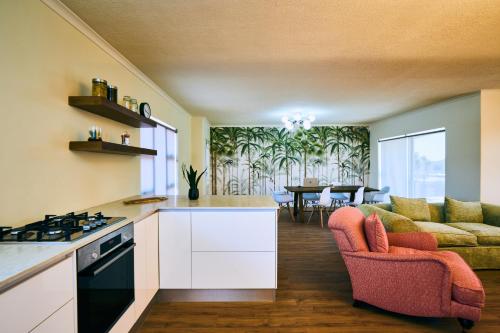 a kitchen and living room with a couch and a table at The Palms Luxury Suites in Swakopmund