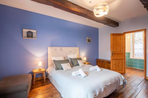 1 dormitorio con 1 cama blanca grande y paredes azules en Gite des Gargouilles, en Saint-Valery-sur-Somme
