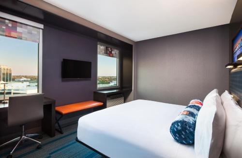 Habitación de hotel con cama, escritorio y ventana en Aloft Sarasota en Sarasota