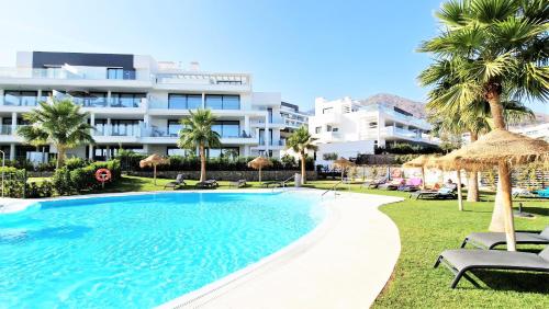 豐希羅拉的住宿－AA Guest - Luxury Paradise Eco Apartment Higueron，一座大建筑前的游泳池