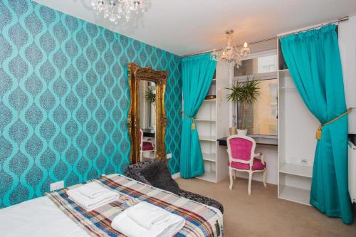 a blue bedroom with a bed and a mirror at Unique & Welcoming 2BD Flat in Limehouse in London