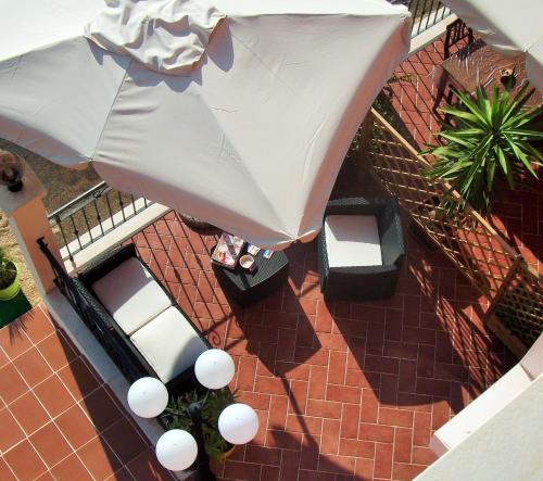 an overhead view of a patio with chairs and an umbrella at Hotel Bellavista S'Archittu in S'archittu Cuglieri