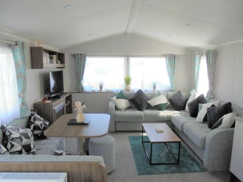 a living room with a couch and a table at Kingfisher : Seasons:- 8 Berth, Central Heated, Close to site shop in Ingoldmells