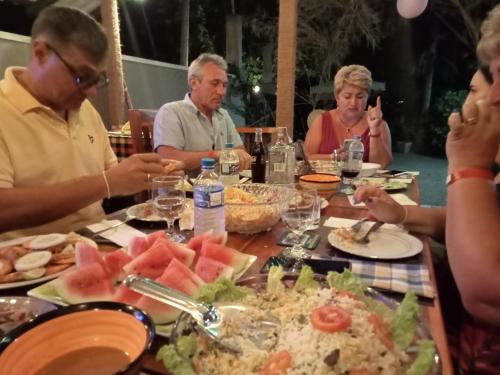 a group of people sitting around a table eating food at Inn Sea Horizon Ahungalla in Ahungalla