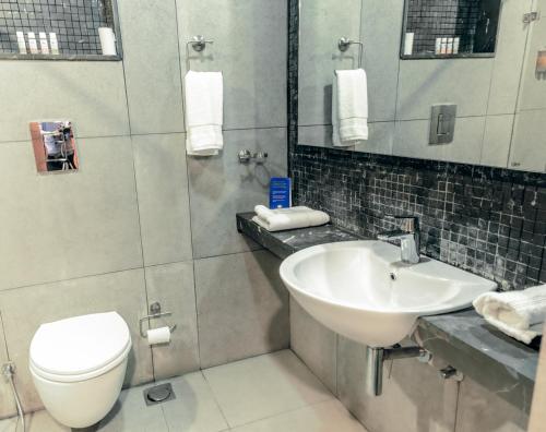a bathroom with a sink and a toilet and a mirror at Mountain Retreat Kodai in Kodaikānāl