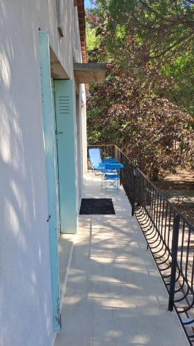 un porche con una puerta azul y un banco azul en LOU SOLEIOU SAINT HILAIRE, en Luynes