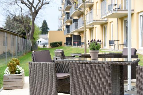 a wicker table and chairs on a patio at Amedia Luxury Suites Graz, Trademark Collection by Wyndham in Graz