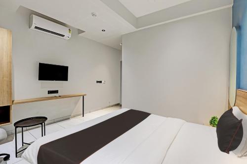 a bedroom with a bed and a tv on the wall at HOTEL LEE PLATINUM in Ahmedabad
