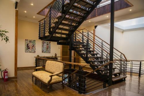 a staircase leading up to a living room with a couch at Hotel Boutique Acontraluz in Valparaíso