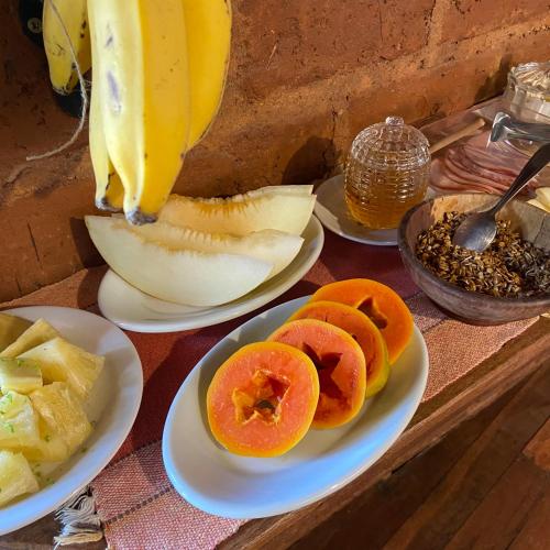 a bunch of plates of fruit on a table at Abrigo Cipó in Serra do Cipo