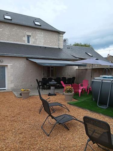 a patio with two chairs and a table and chairs at Superbe gite familial pour 10 personnes à Gizeux in Gizeux