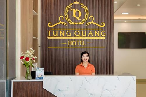 a woman standing behind a counter in a hotel lobby at Tung Quang Hotel in Cat Ba
