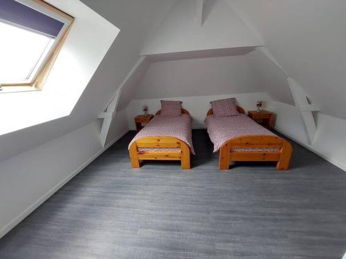 a attic room with two beds and a window at Superbe gite familial pour 10 personnes à Gizeux in Gizeux