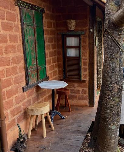 a table and two stools sitting on a patio at Abrigo Cipó in Serra do Cipo