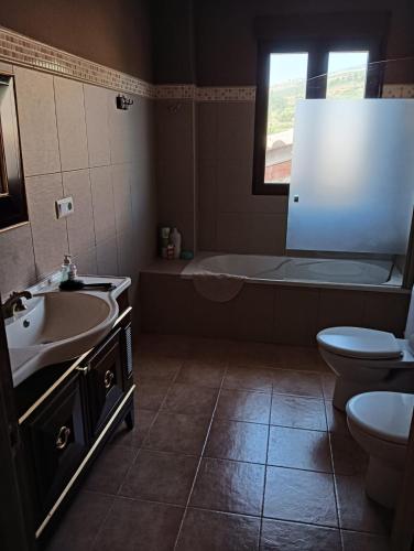 a bathroom with a tub and a sink and a toilet at La cerrada in El Collado