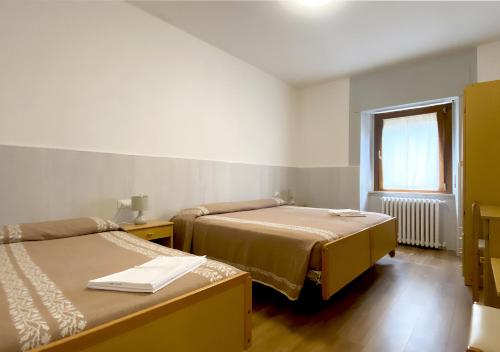 a room with two beds and a window at Locanda del Buon Cammino in Chiusi della Verna
