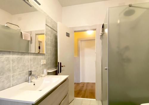 a white bathroom with a sink and a shower at Locanda del Buon Cammino in Chiusi della Verna