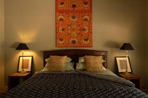 a bedroom with a bed with two lamps and a painting at Luna Laguna in Kalpitiya