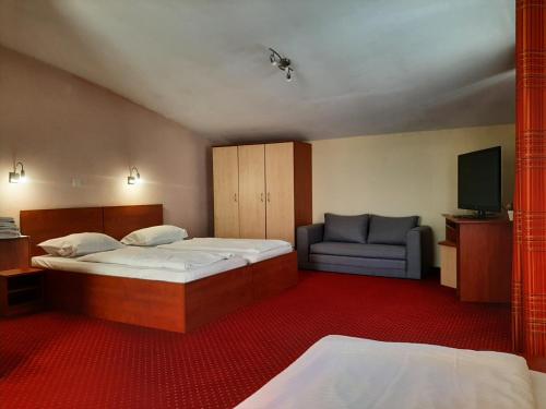 een hotelkamer met 2 bedden en een bank bij Pensiune Safrane in Băile Herculane