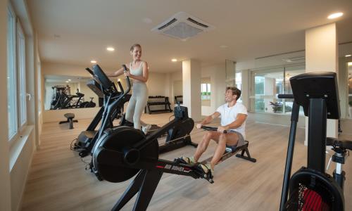 a man and a woman on a treadmill in a gym at RH Silene Hotel & Spa 4 Sup in Castellón de la Plana