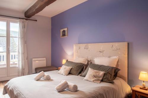 a bedroom with a large bed with blue walls at Gite des Gargouilles in Saint-Valery-sur-Somme